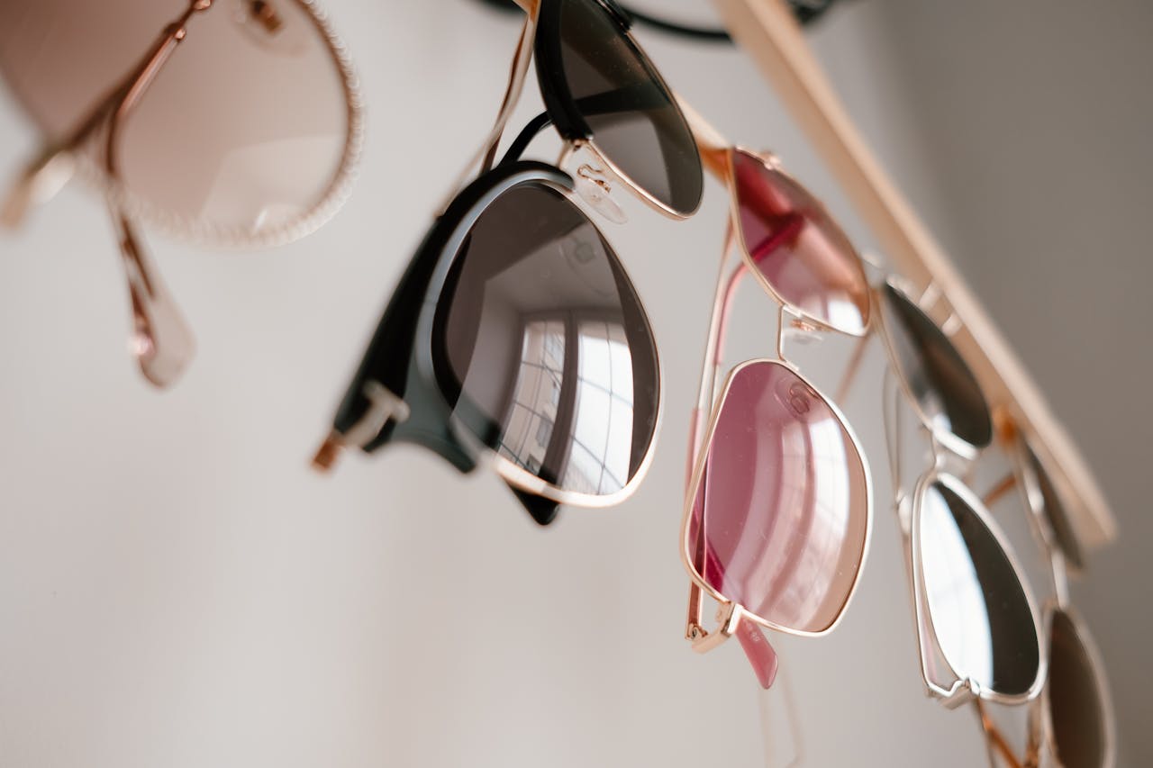 our-mission-01 Stylish sunglasses in various colors hanging indoors with soft reflections.