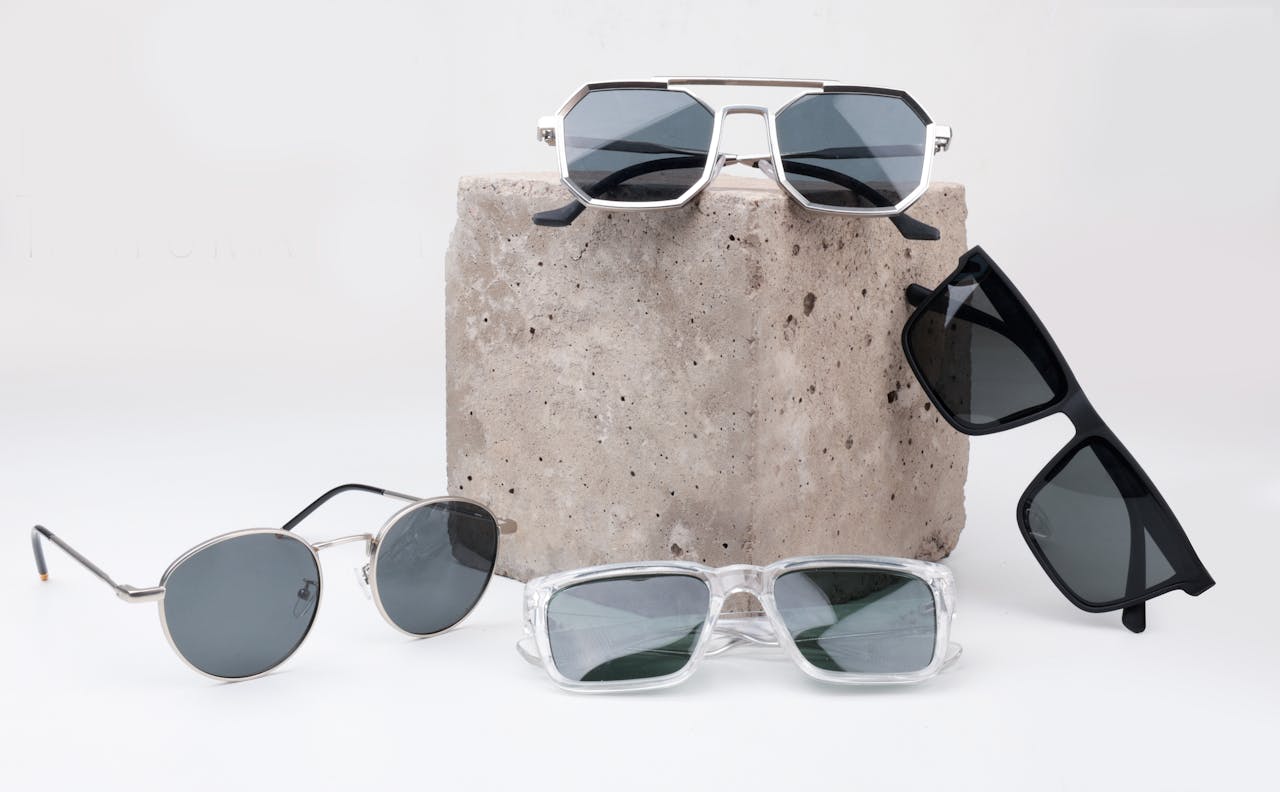 A diverse selection of sunglasses displayed on a textured concrete block, perfect for summer fashion.